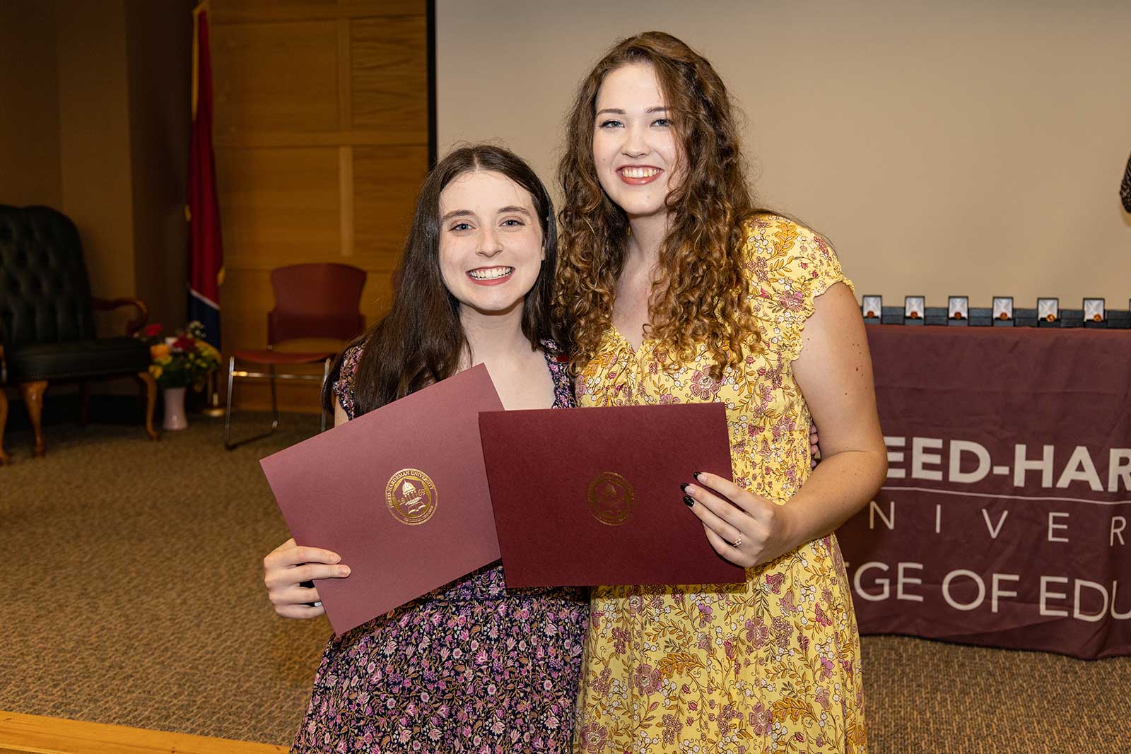 two girls holding certificates