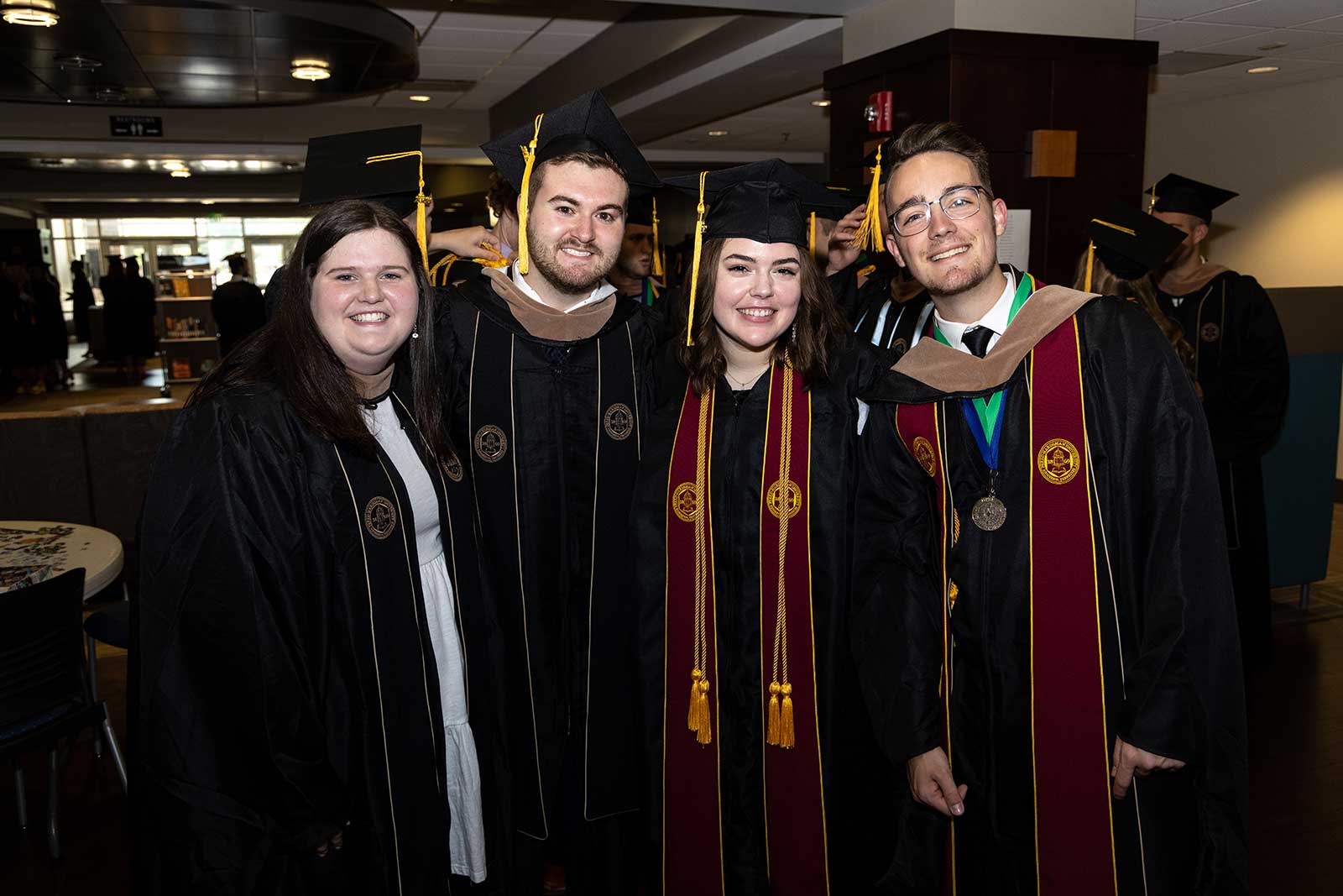 group of four students after commencement celebrating