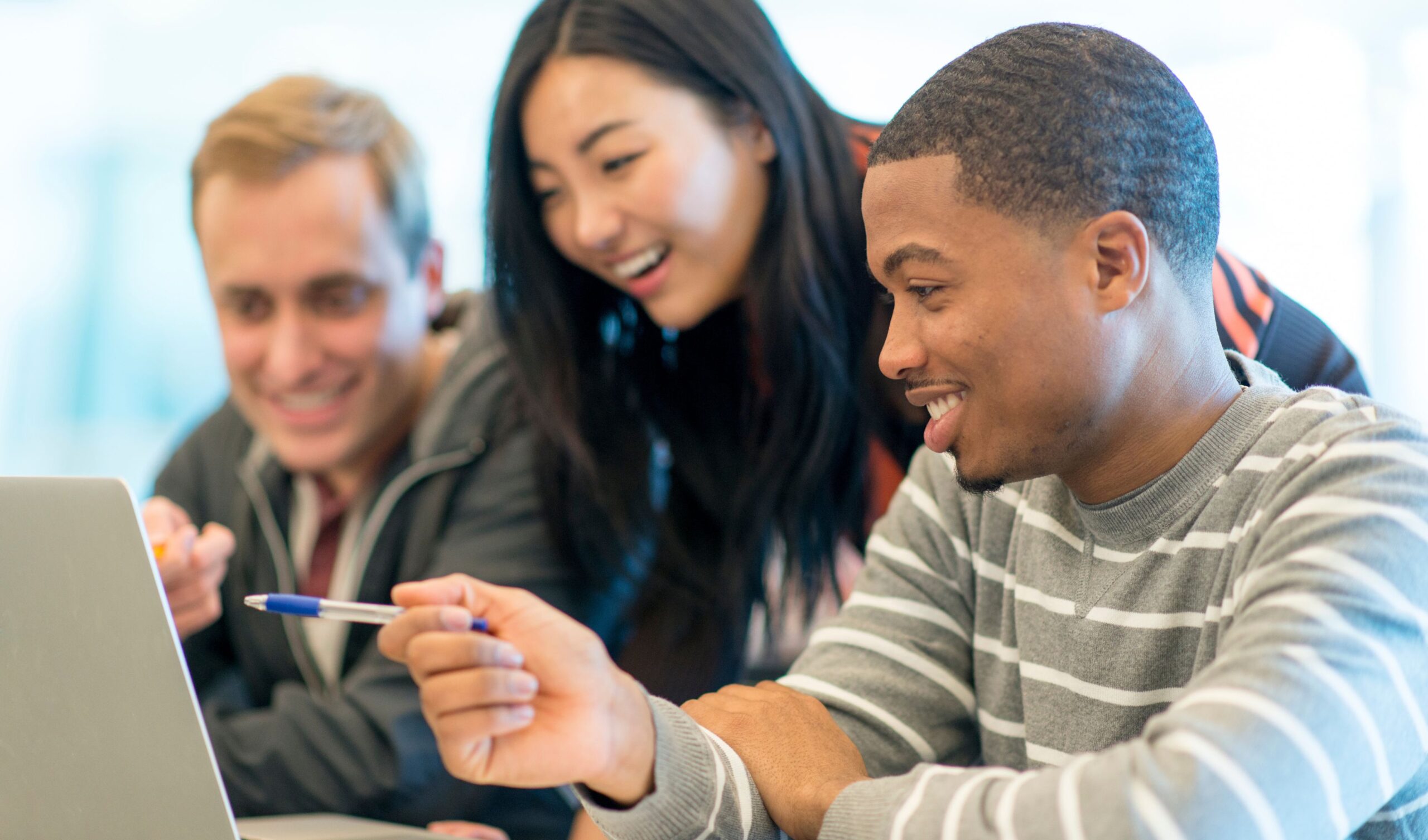 Diverse group looking at laptop together