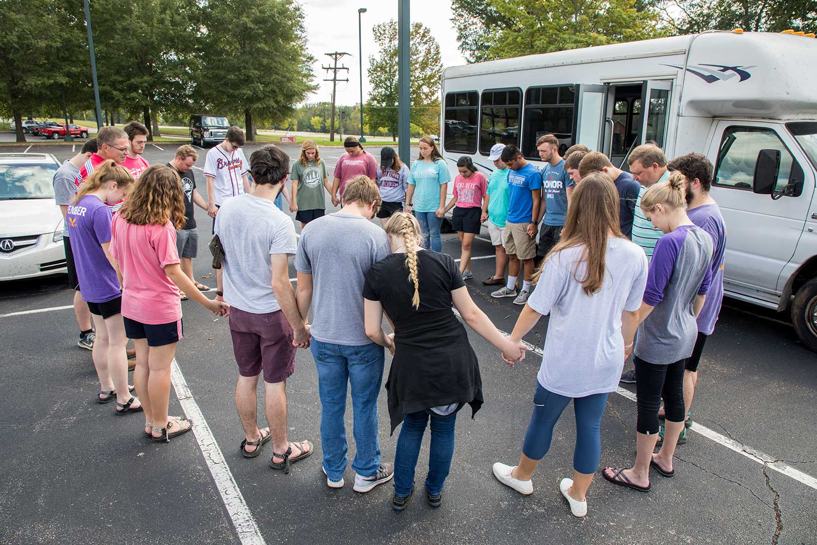 new-students in prayer by buy outside