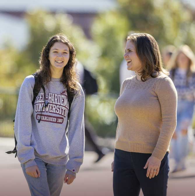 two transfer students outside talking and smiling